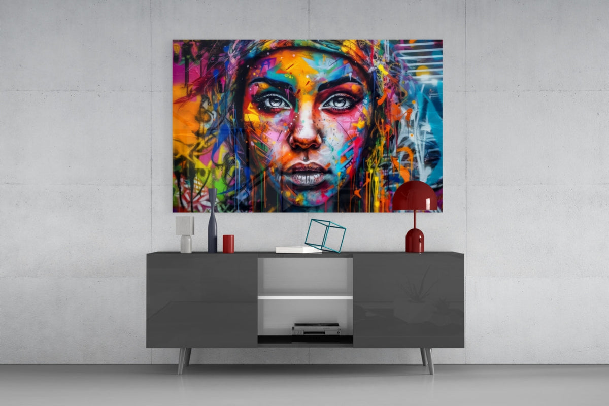 Wide eyed woman glass wall art above a gray sideboard with a red dome lamp