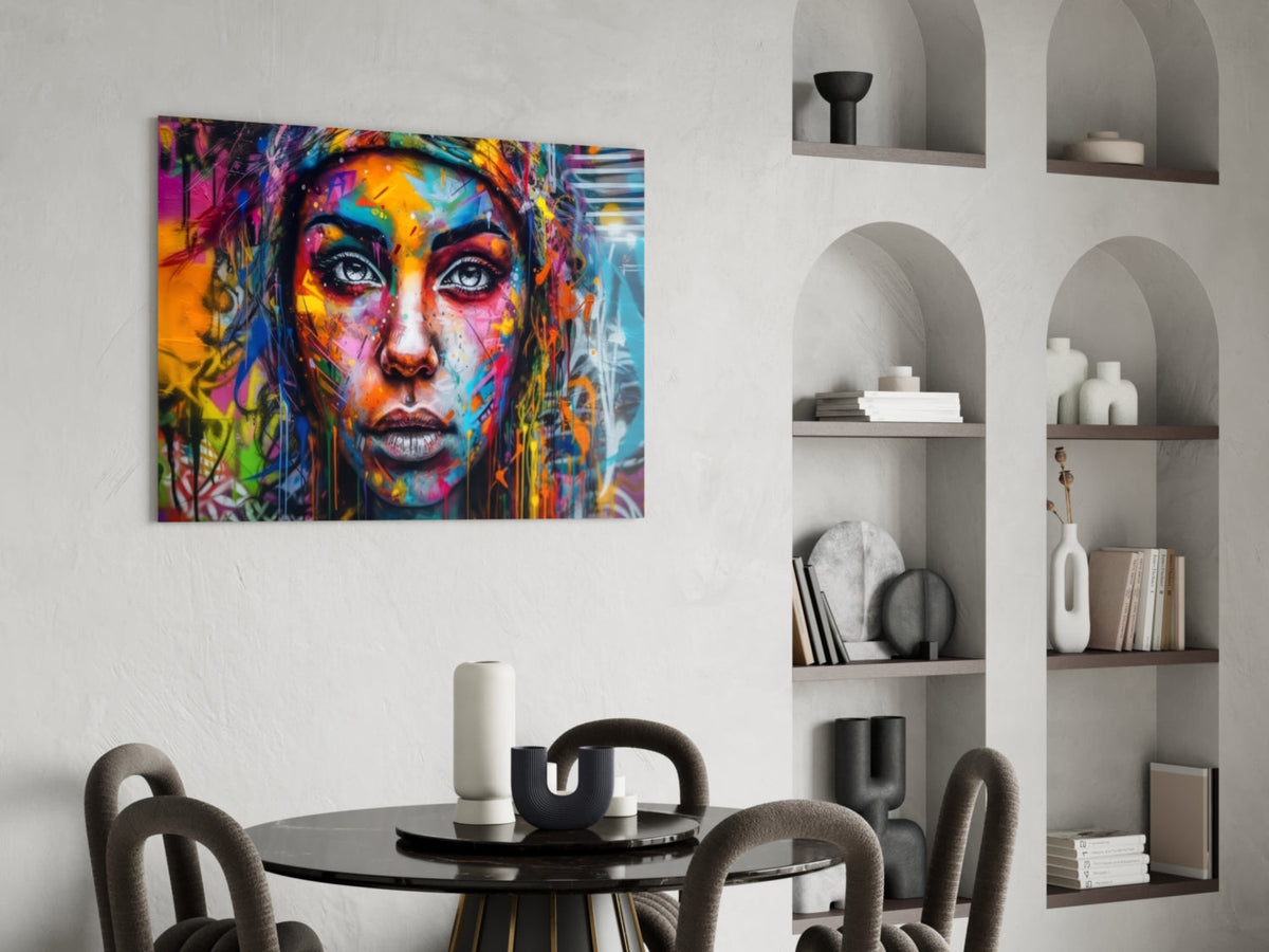 Wide eyed woman glass art above a round dining table with black chairs
