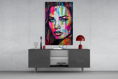 Newsprint drip woman glass wall art above a gray sideboard with a small table lamp on a white wall