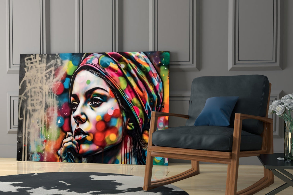 Woman in a polka dot turban glass wall art beside a rocking armchair against gray paneling