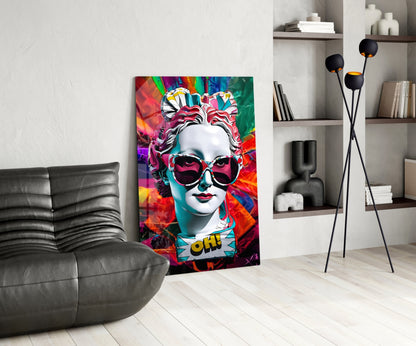 White bust in sunglasses glass wall art leaning beside a black leather lounge chair and shelves