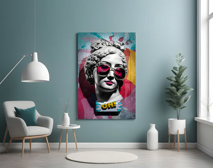 Marble bust in pink sunglasses on teal collage glass wall art on a blue-gray wall above a white armchair and a pendant lamp