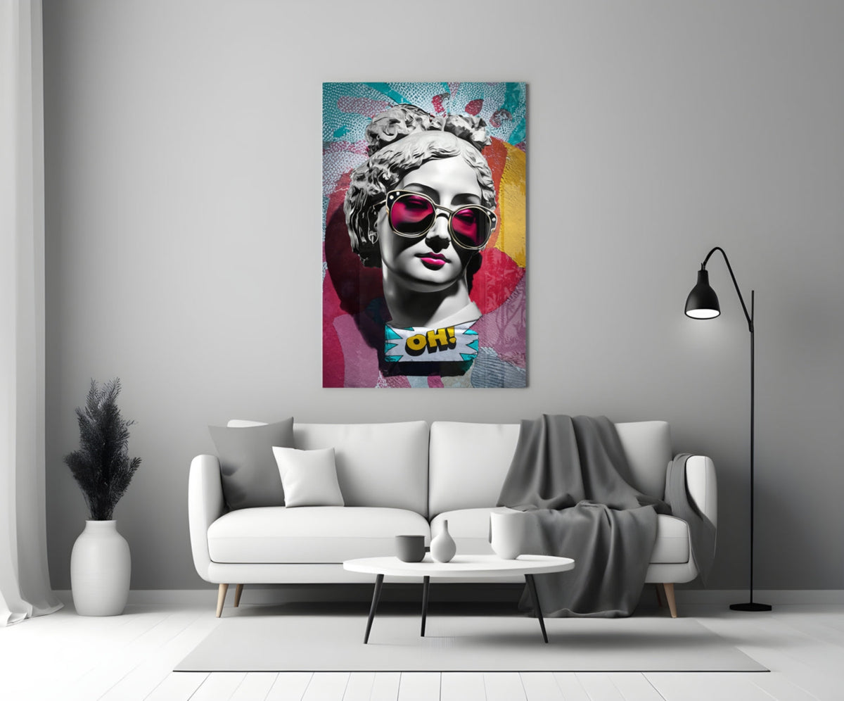 Marble bust in pink sunglasses on teal collage glass wall art above a white sofa and coffee table beside a black floor lamp