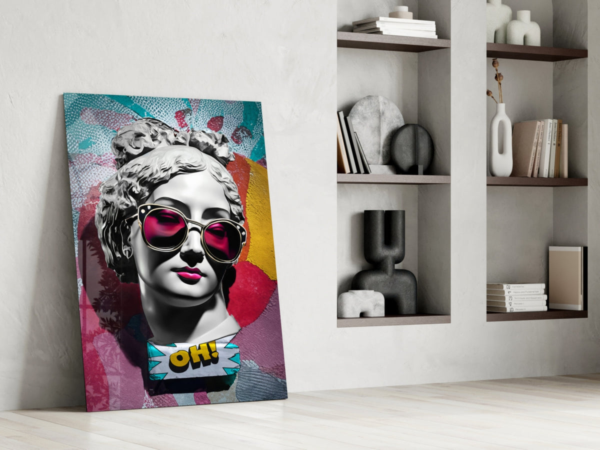 Marble bust in pink sunglasses on teal collage glass wall art leaning against a white wall beside open shelves with vases
