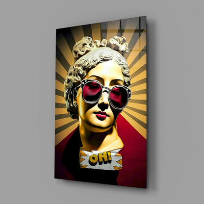 Gold bust in sunglasses on sunburst rays glass wall art angled against a soft gray backdrop