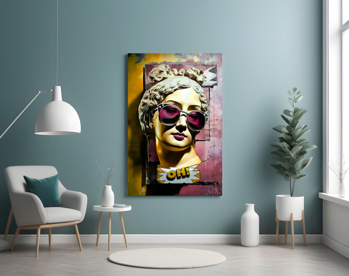 Gold bust in sunglasses on torn pink wall glass wall art on a blue-gray wall above a white armchair and a pendant lamp