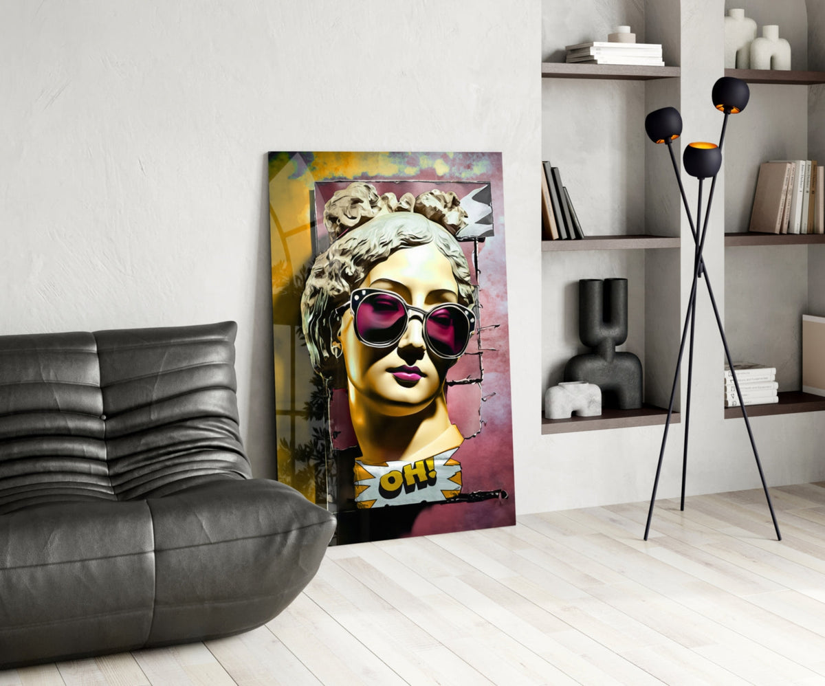 Gold bust in sunglasses on torn pink wall glass wall art leaning beside a black leather lounge chair and open shelves
