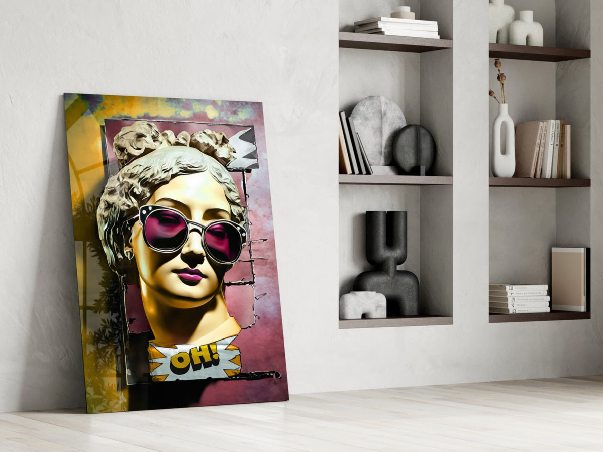 Gold bust in sunglasses on torn pink wall glass wall art leaning against a white wall beside open shelves with vases