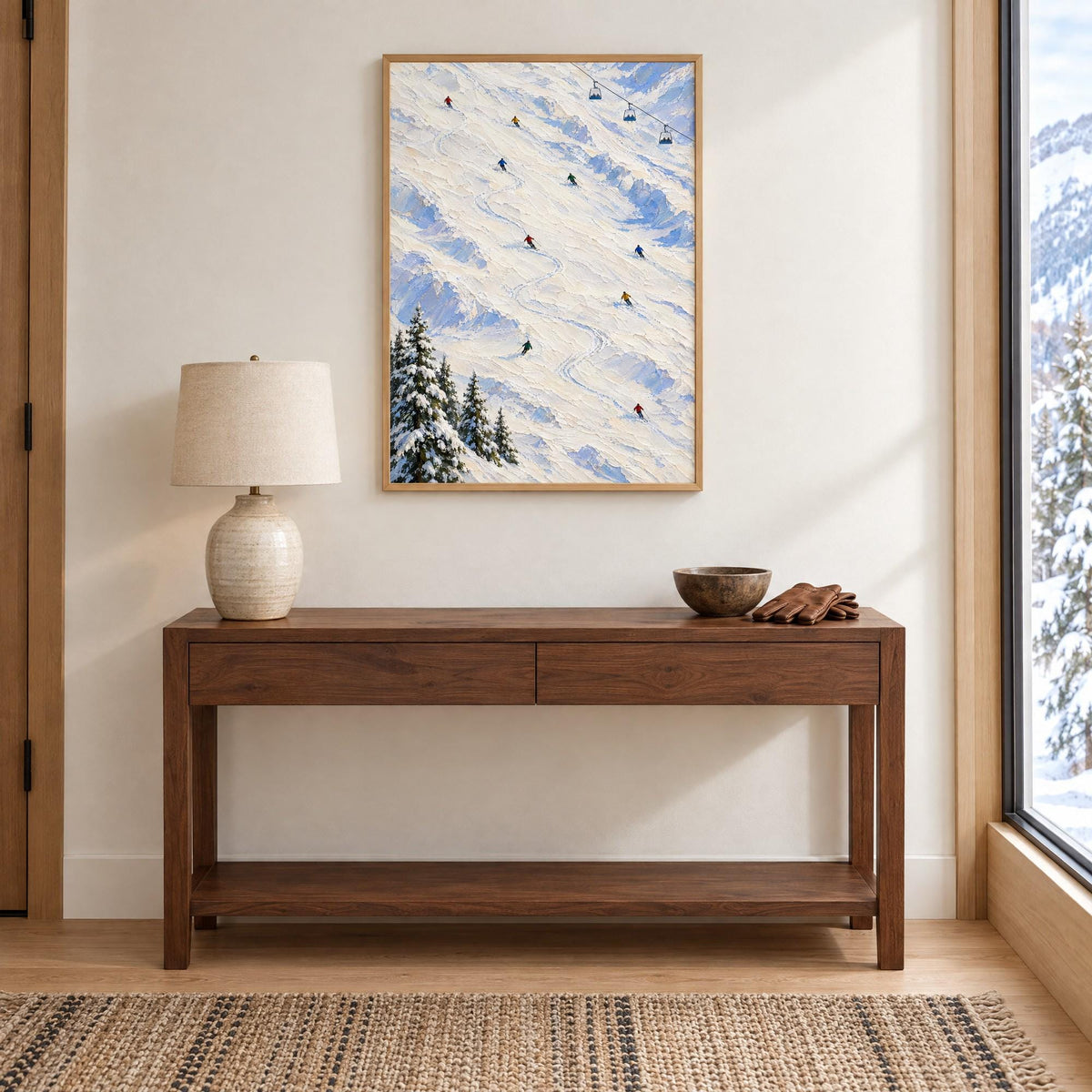 Ski slope wall art in a natural wood frame above an entry console in a bright mountain home, shown to scale