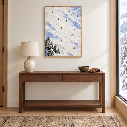 Ski slope wall art in a natural wood frame above an entry console in a bright mountain home, shown to scale