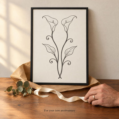 Framed calla lily print with kraft paper and ivory ribbon on a table, captioned For your iron anniversary