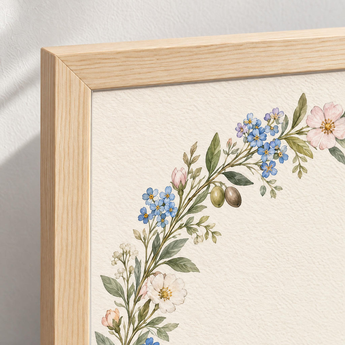 Close-up of the light pine frame corner and the watercolor forget-me-nots printed edge to edge on cream paper