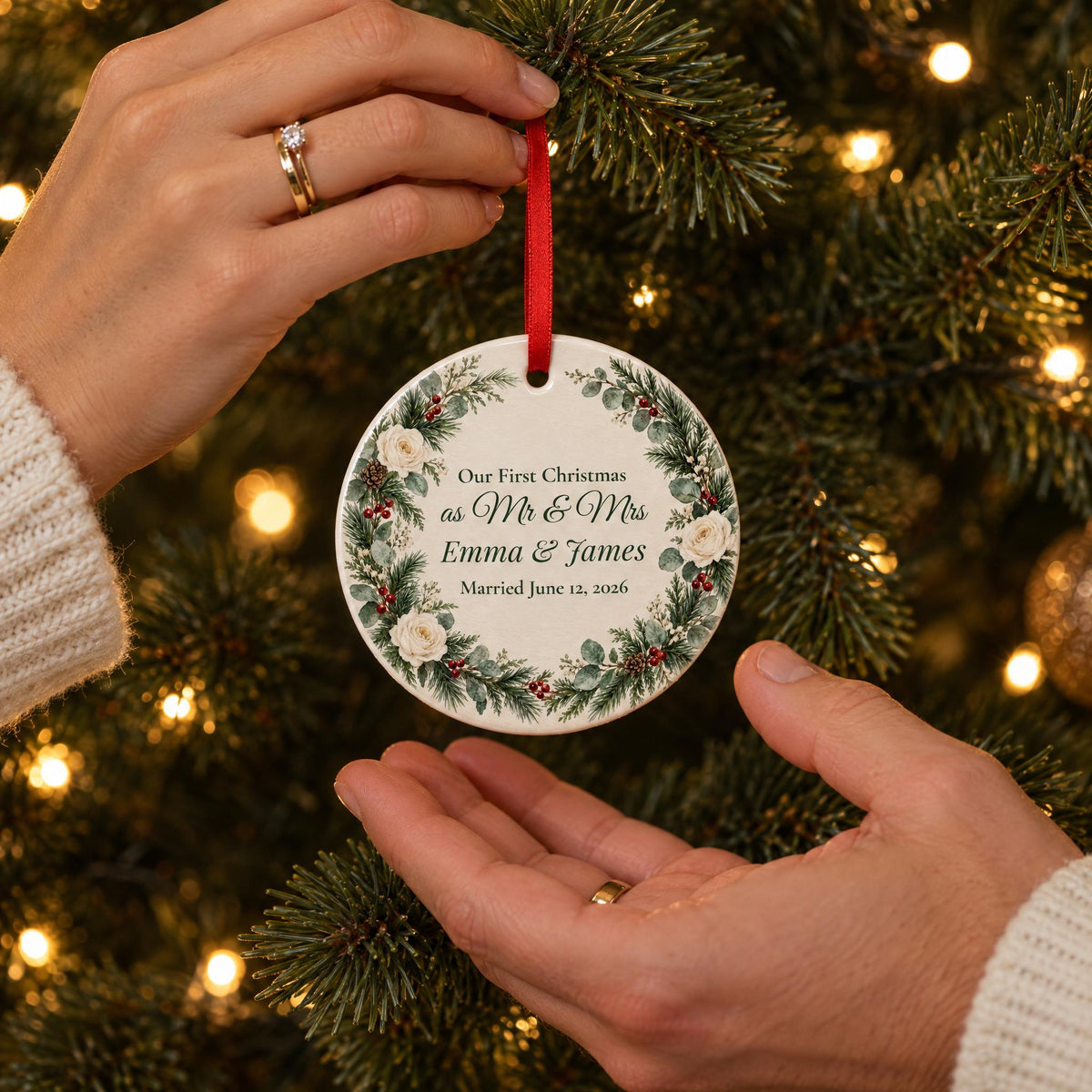 First Christmas married ornament with names, hung on the tree by a newlywed couple's hands