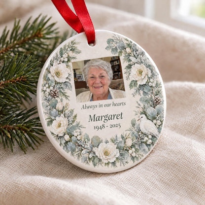 Close-up of the glossy white ceramic edge and red ribbon on the memorial photo ornament with a watercolor wreath