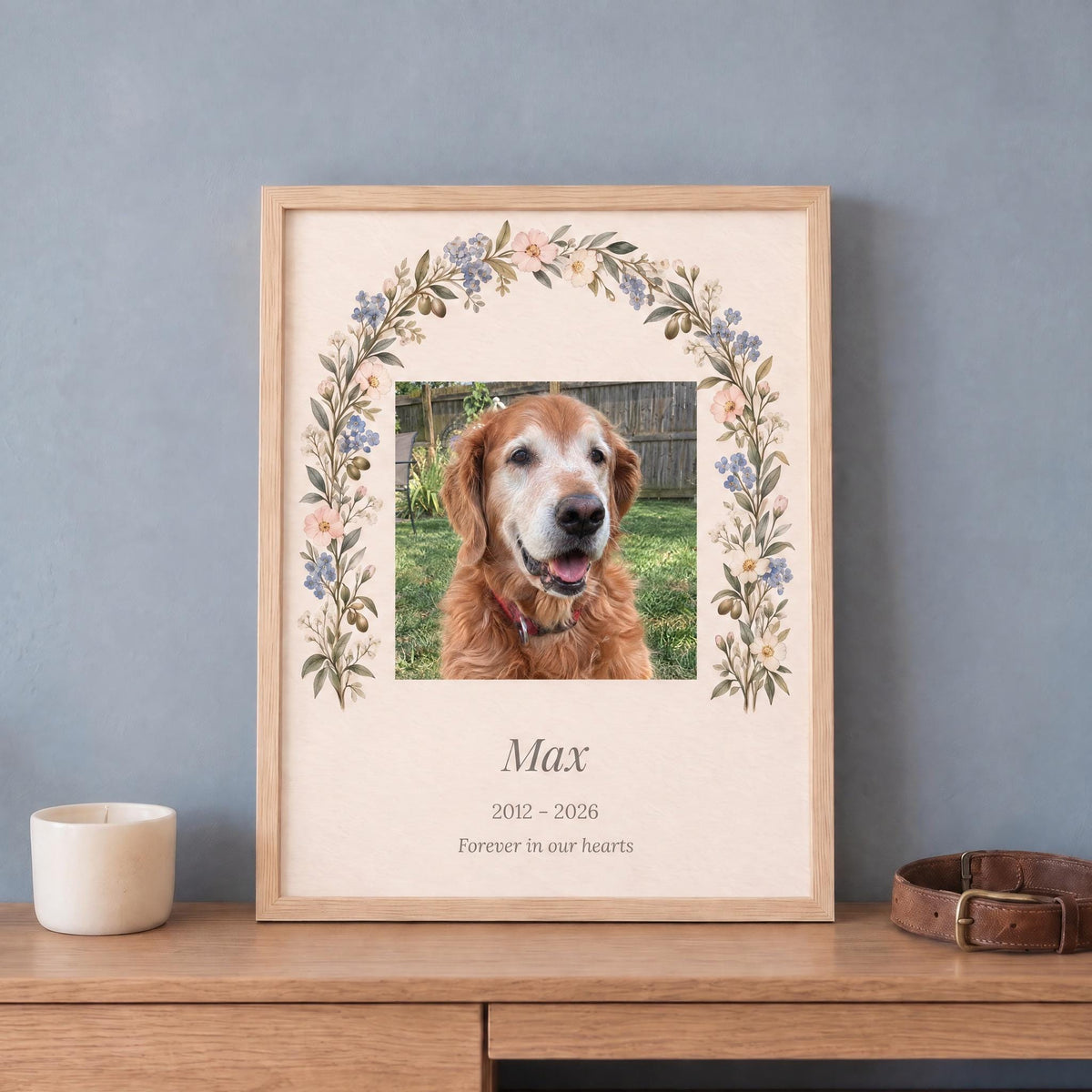 Pet memorial gift: custom dog photo print with name and years in a light wood frame, leaning on a dresser by a collar