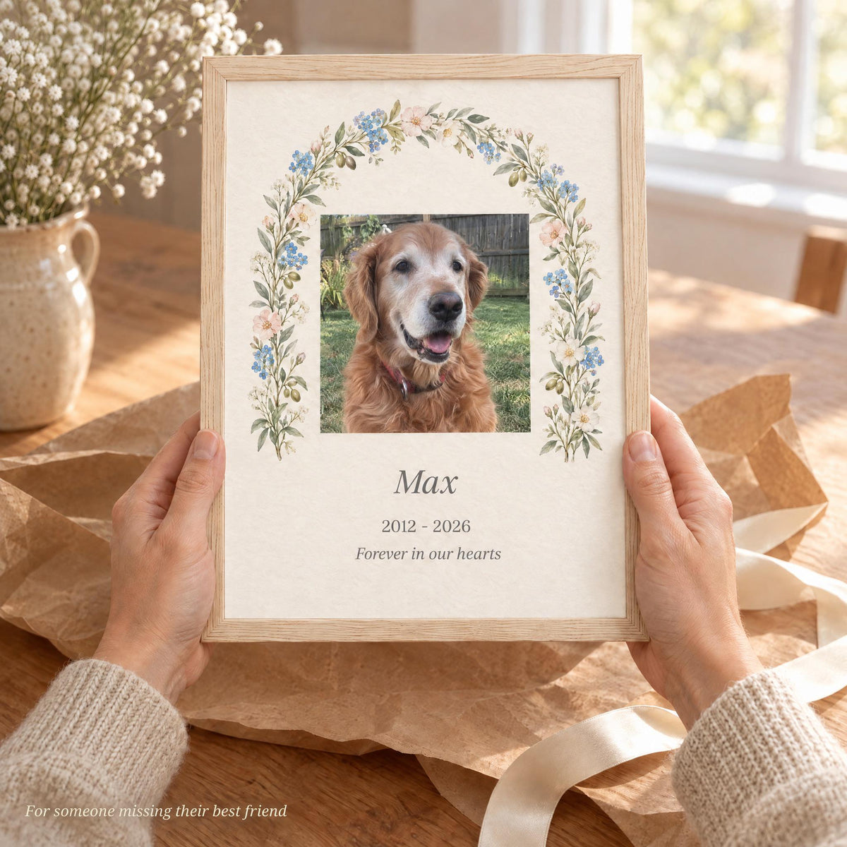 Hands holding a framed dog memorial gift with name and years over kraft paper, a gentle pet sympathy gift