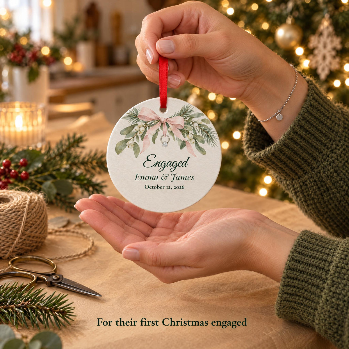A friend holding a first Christmas engaged ornament over kraft paper, a gift for the newly engaged couple