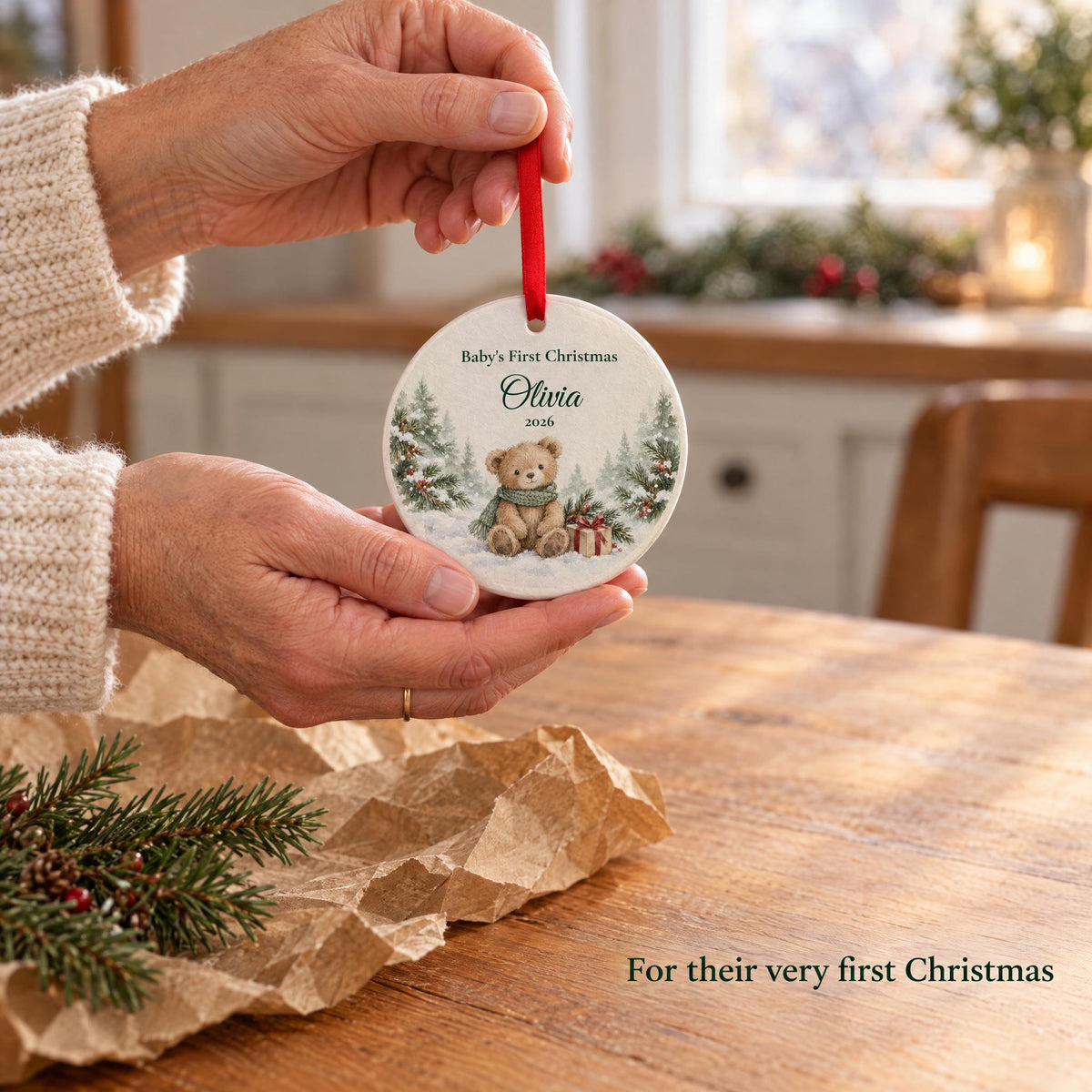 A grandmother giving a personalized baby's first Christmas ornament over kraft paper, a gift for new parents