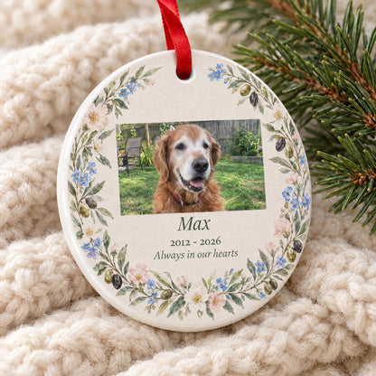 Close-up of the glossy white ceramic edge and red ribbon on the dog memorial ornament with a watercolor wreath