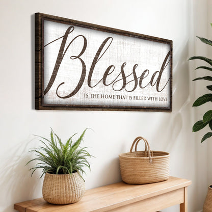 Linen-look canvas sign with a dark wood-look edge and large brown script reading Blessed is the home that is filled with love