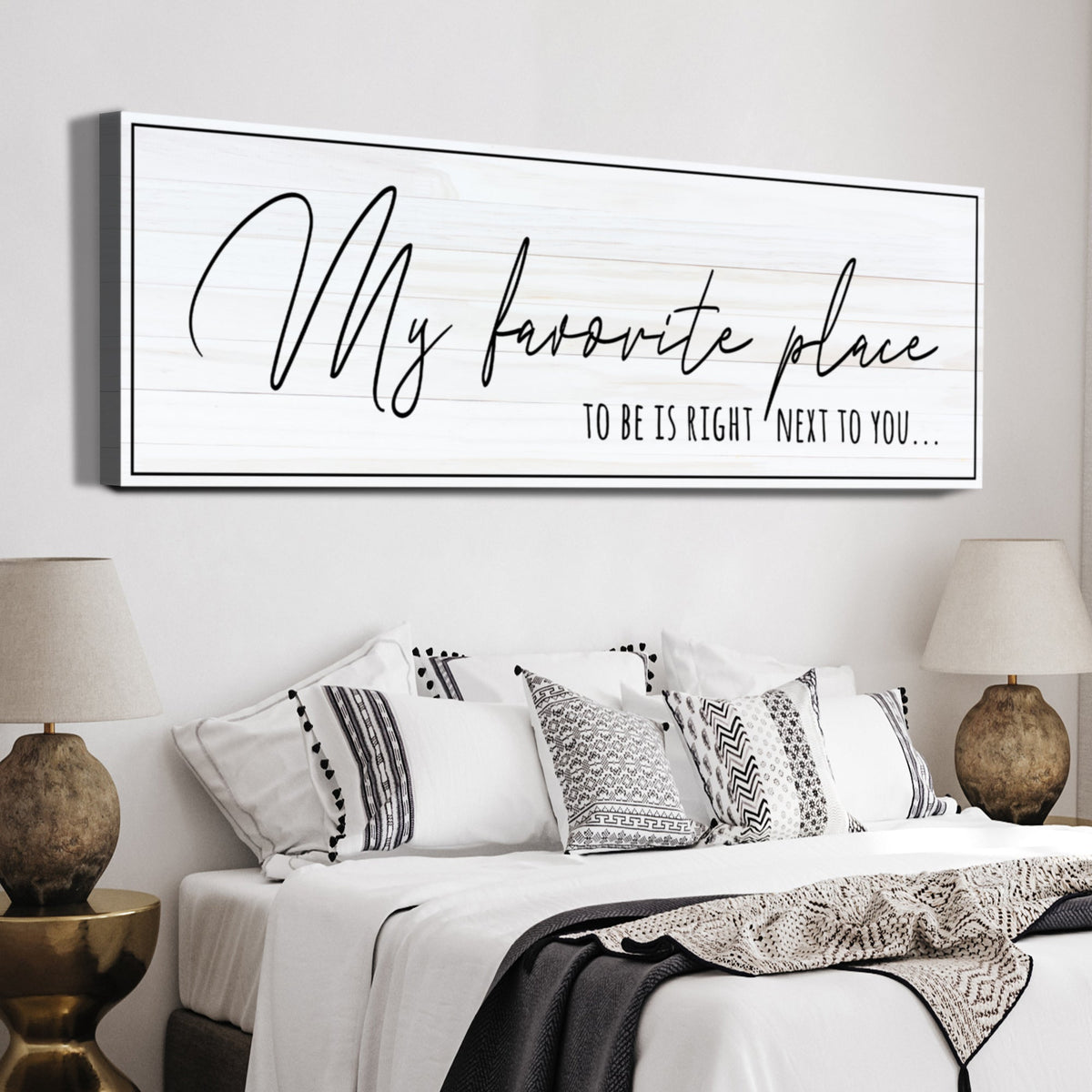 My Favorite Place to Be Is Right Next to You canvas sign in thin black handwriting on white, above a bed