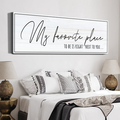 My Favorite Place to Be Is Right Next to You canvas sign in thin black handwriting on white, above a bed
