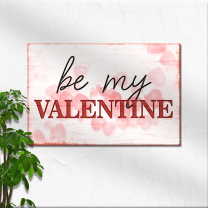 Be My Valentine canvas on a white wall beside a plant, close view