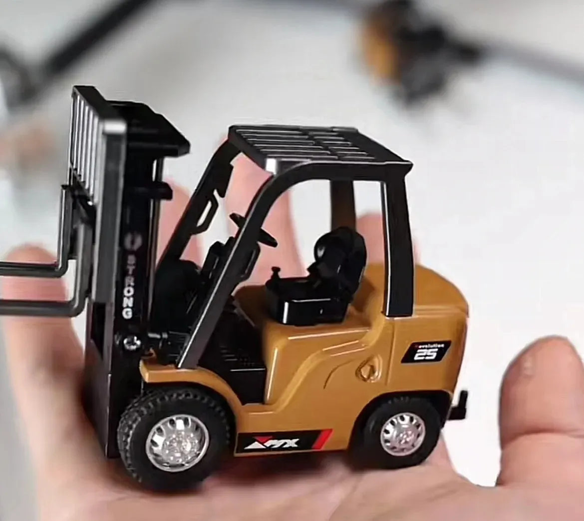 Small toy forklift held in a hand with a blurred background