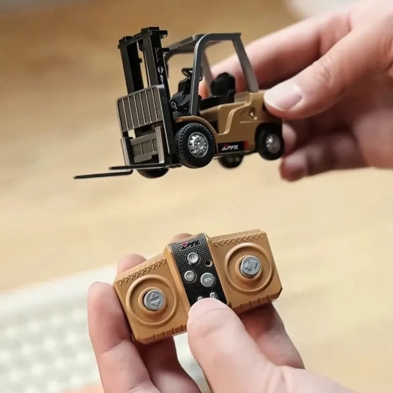 Miniature forklift toy held by a hand with a blurred background