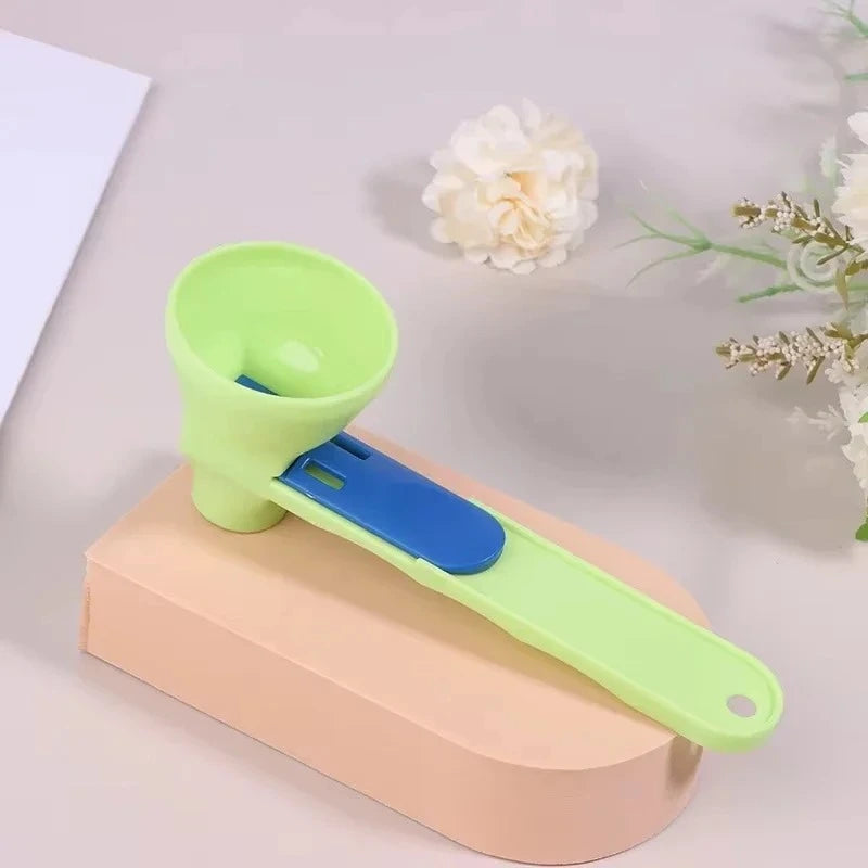 Green and blue measuring powder scoop on a beige block with flowers in the background