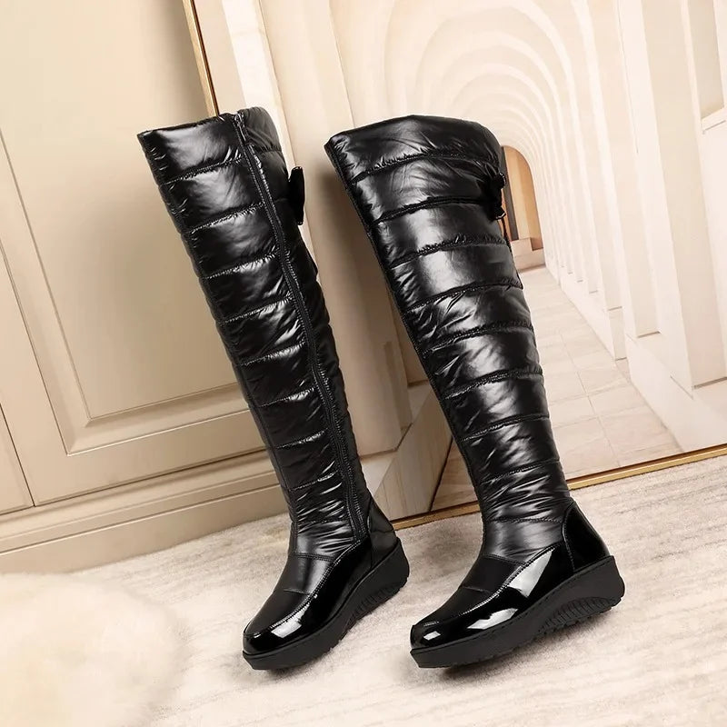 Black knee-high boots with quilted design on a light background