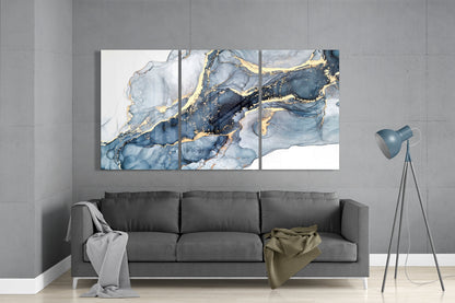 Blue and gold marble ink glass wall art set above a gray sofa beside a tripod floor lamp