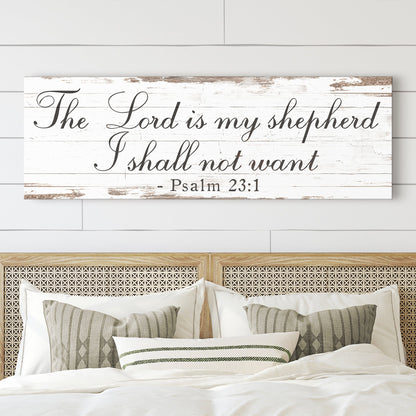 Long canvas sign with The Lord is my shepherd, I shall not want, Psalm 23:1, in black script on white planks above a bed