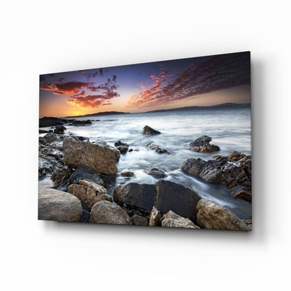 Rocky shore sunset seascape glass wall art with silky waves
