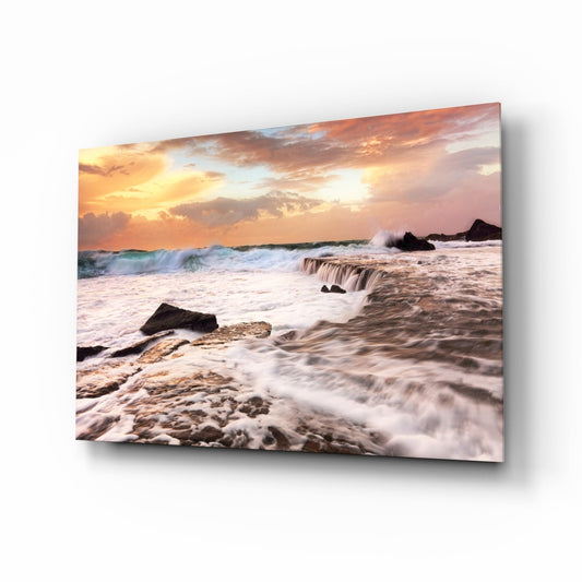 Vicious waves glass wall art, white surf crashing over coastal rocks at peach-coral golden hour