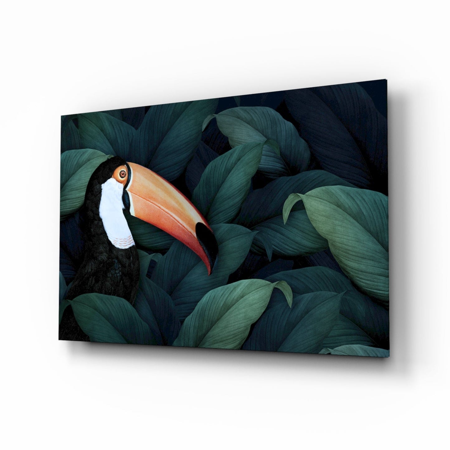 Toucan glass wall art among teal jungle leaves