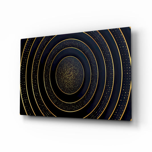 Glass print of thin gold concentric rings and dotted gold bands around a gold center on a black background