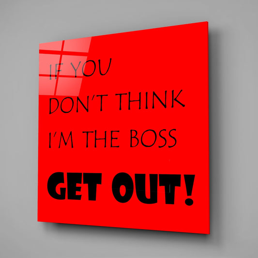 Funny boss quote in black text on red square glass wall art on a gray wall with a soft shadow