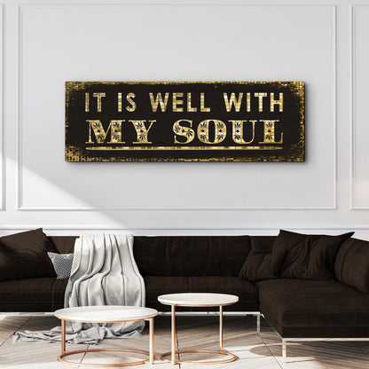It Is Well hymn canvas sign in black and gold above a dark sofa with round tables