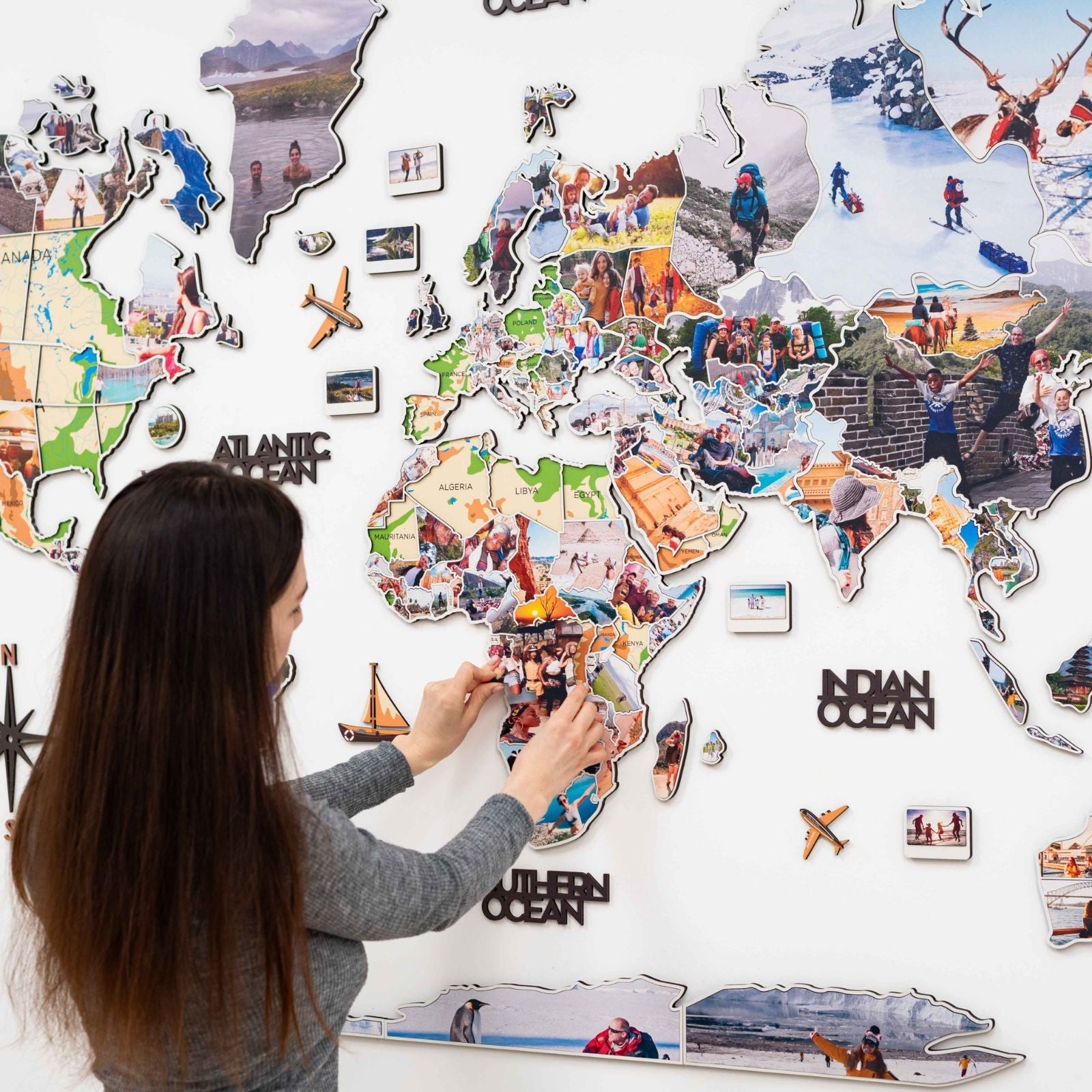 Wood world map wall art with photo frames on a living room wall