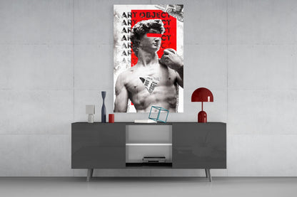 Marble statue on red newsprint collage glass wall art above a gray sideboard with a red table lamp on a concrete wall