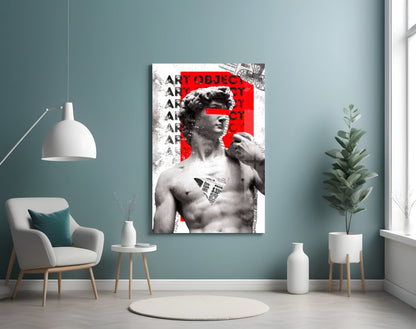 Marble statue on red newsprint collage glass wall art on a blue-gray wall above a white armchair and a pendant lamp
