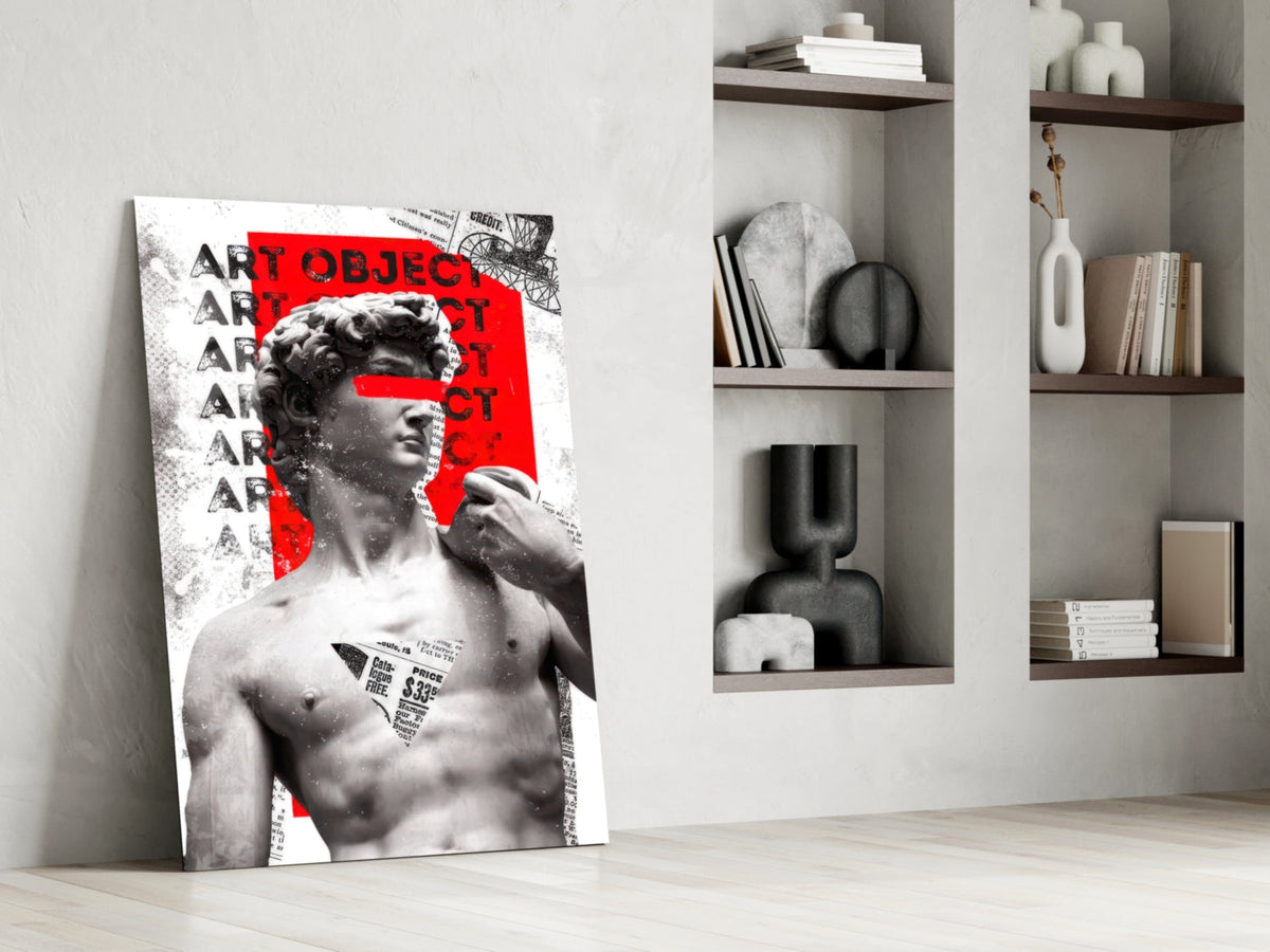 Marble statue on red newsprint collage glass wall art leaning against a white wall beside open shelves with vases