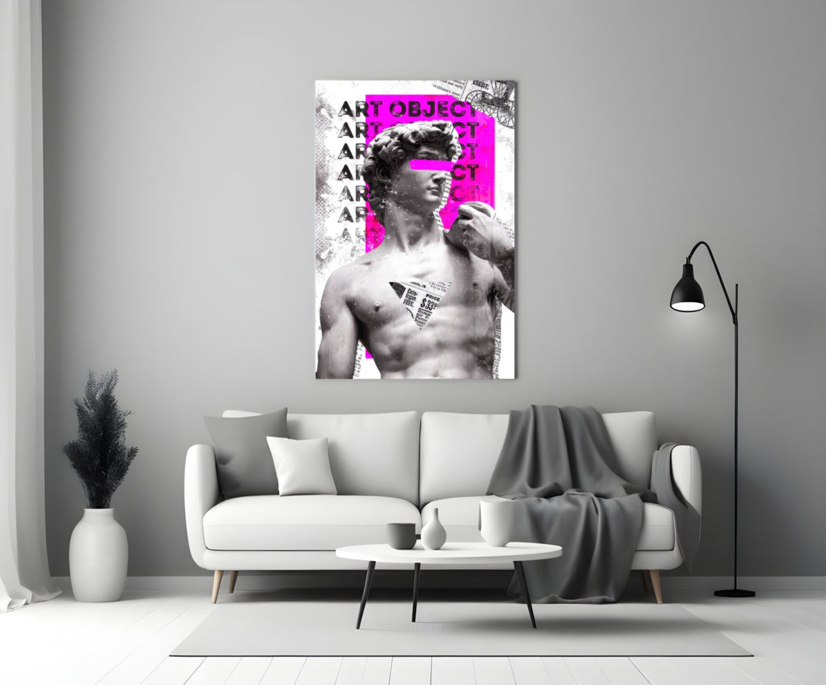 Marble statue on magenta newsprint collage glass wall art above a light gray sofa with a gray throw and a black floor lamp