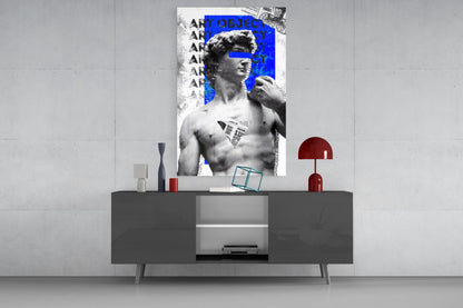 Marble statue on blue newsprint collage glass wall art above a gray sideboard with a red table lamp on a concrete wall