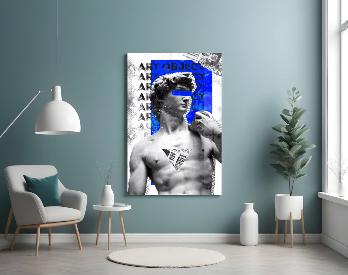 Marble statue on blue newsprint collage glass wall art on a blue-gray wall above a white armchair and a pendant lamp