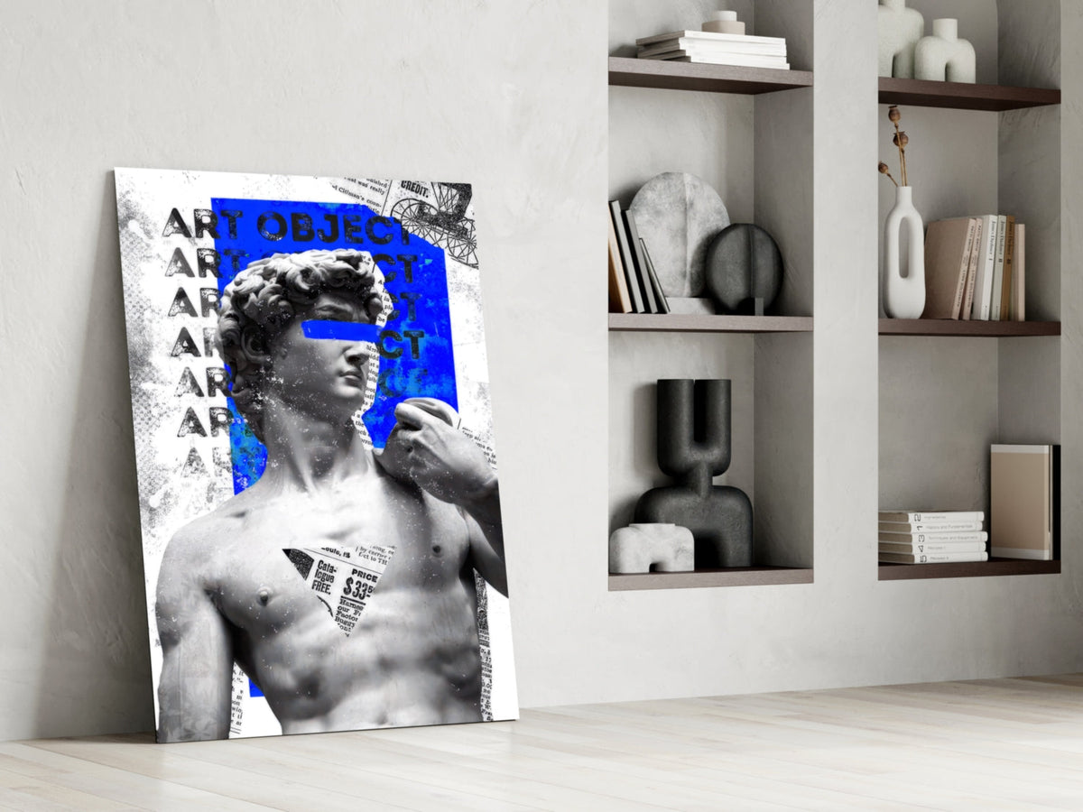 Marble statue on blue newsprint collage glass wall art leaning against a white wall beside open shelves with vases