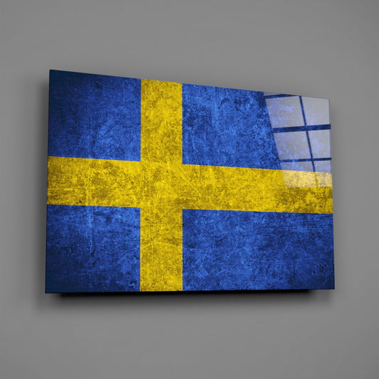 Weathered royal blue Sweden flag glass wall art on a gray wall with a window reflection on the glass