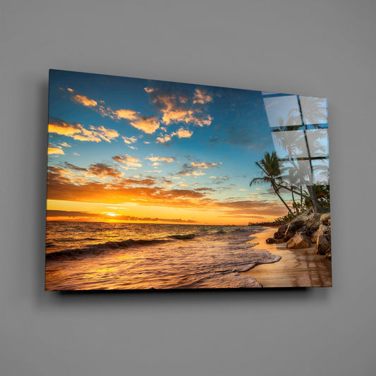 Tropical beach sunset glass wall art on a gray wall, light reflecting off the glossy front