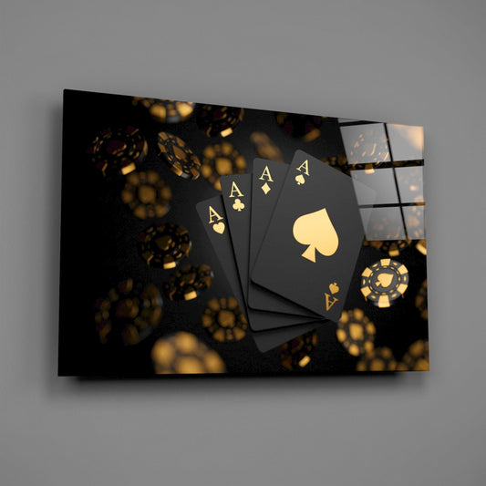 Black aces and gold chips glass wall art hanging on a plain gray wall